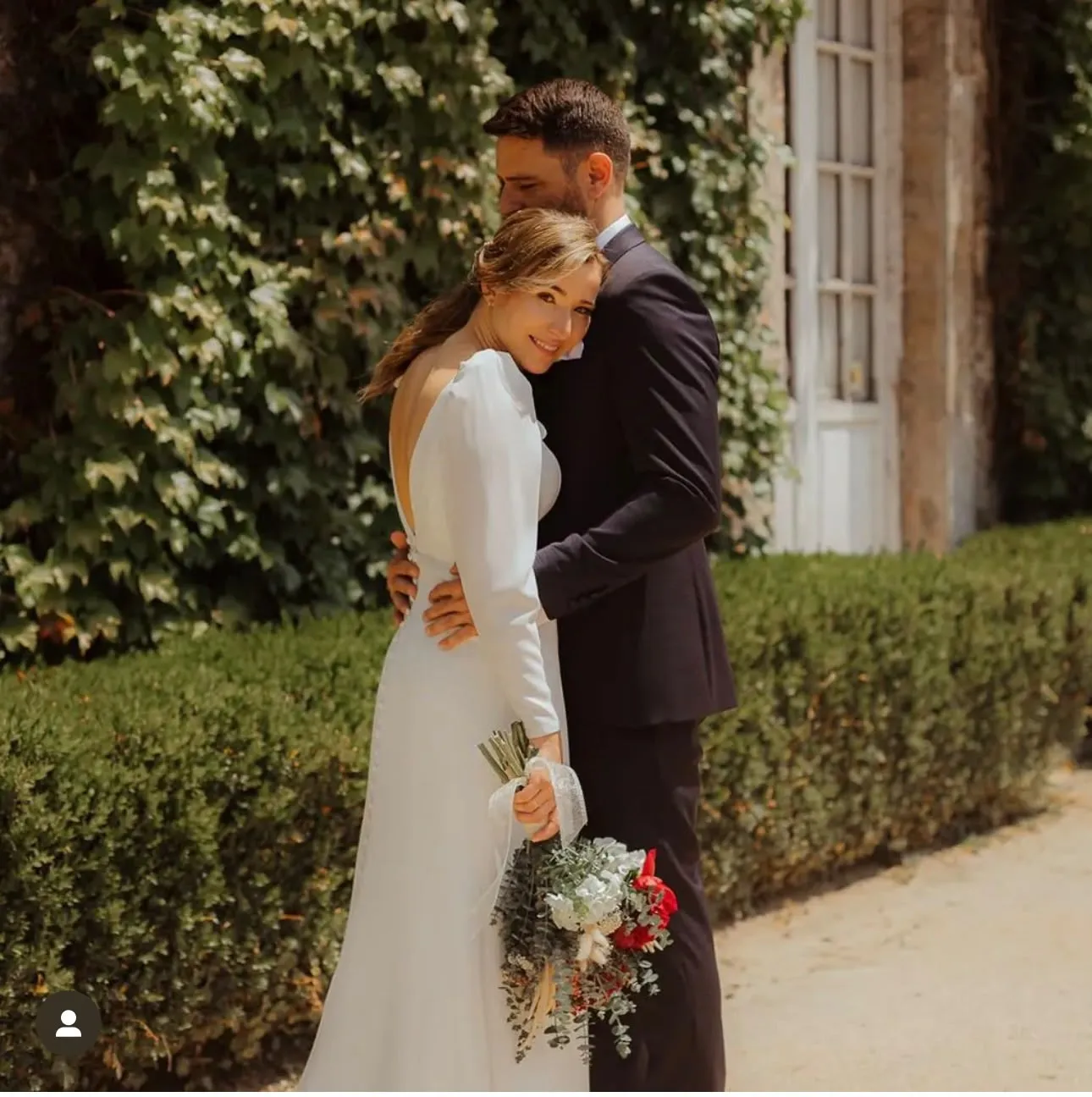 Novia y novio abrazados en un jardín el día de su boda